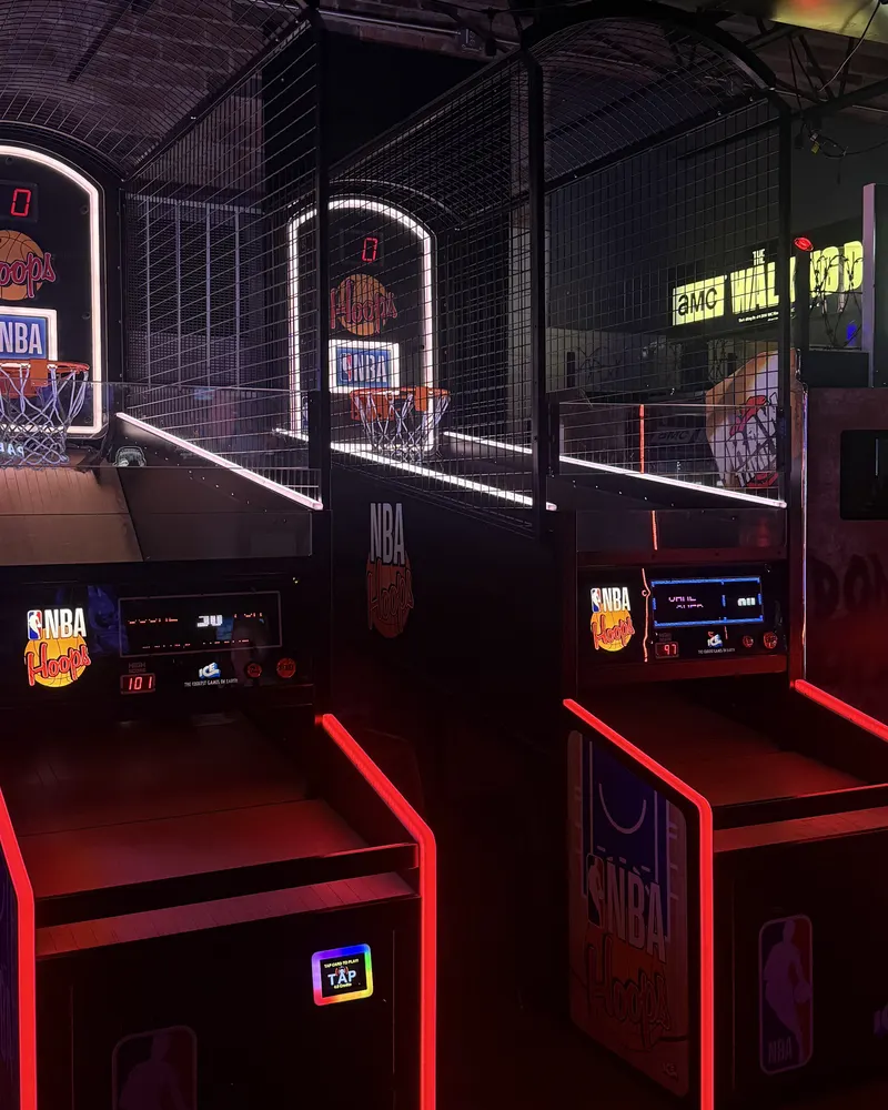 Two NBA basketball arcade machines lit in red